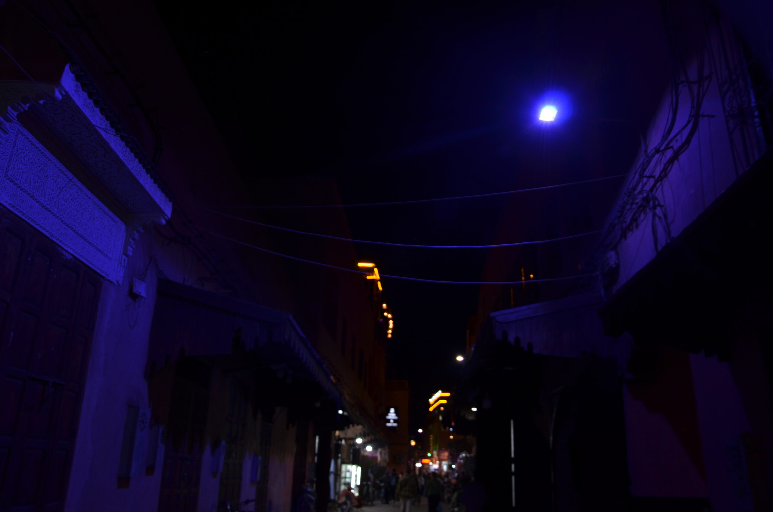 Narrow street at night under blue light